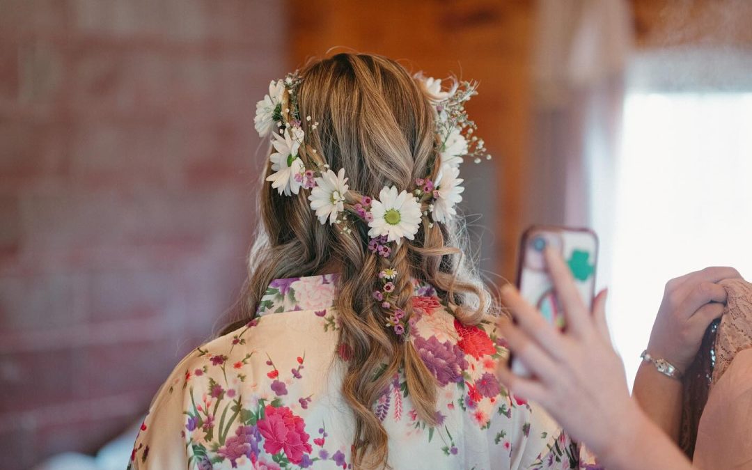 Woman with long hair adorned with a floral crown, wearing a floral kimono, seen from the back.